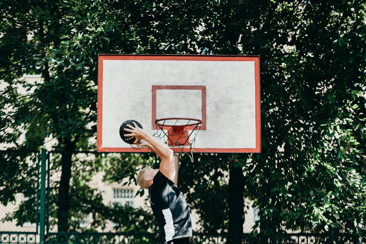 Man Jumping with Ball to Basketball Hoop